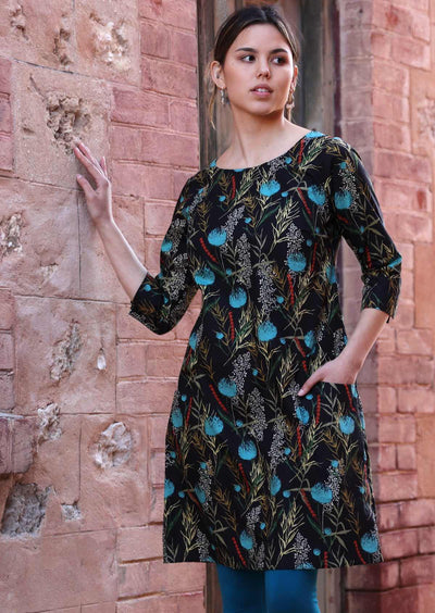 Model wears botanical print with teal on black base cotton dress