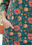 Knee length cotton dress with A line skirt and pocket in dark green based floral print.