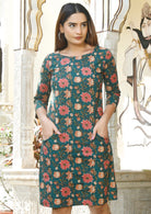 Model with both the hands in pocket wears green floral print dress with round neckline, A line skirt and 3/4 sleeves