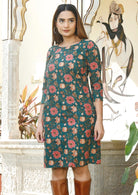 Model in knee length cotton dress with round neckline, 3/4 sleeves and pockets.