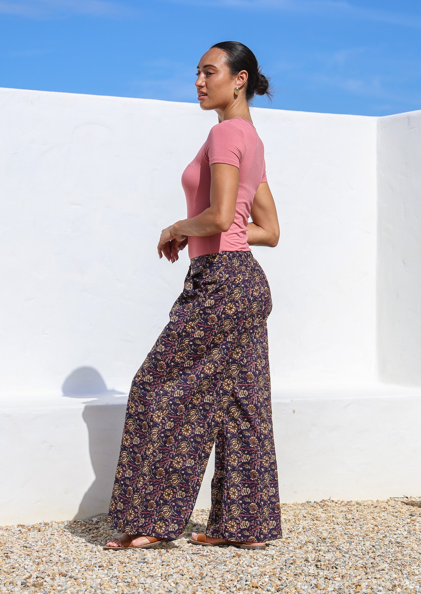Model pairs dark purple based wide leg cotton pants with short sleeve stretch top in rose pink.