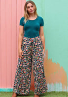 Model wears 100% rayon floral wide leg pants with teal scoop neck top