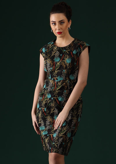 Model wears black based dress with floral pops of blue and red.