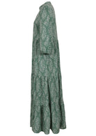 Side view of a full length maxi dress with 3 tiered flowy skirt, mandarin collar, buttoned bodice and pockets