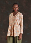 Long sleeve cotton women's blouse with pin tuck pleats and v-neck on model