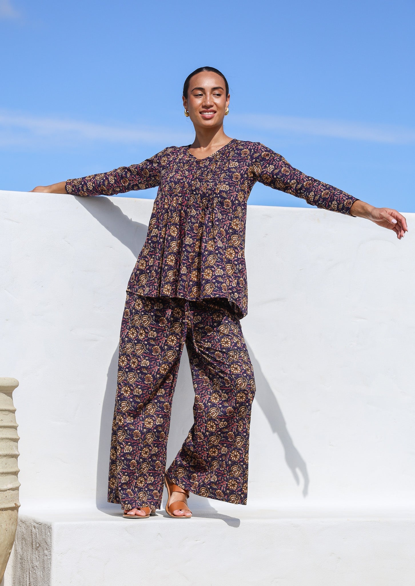 Model wears cotton long sleeve, button through top  with wide leg, floral printed pants in the same pattern.