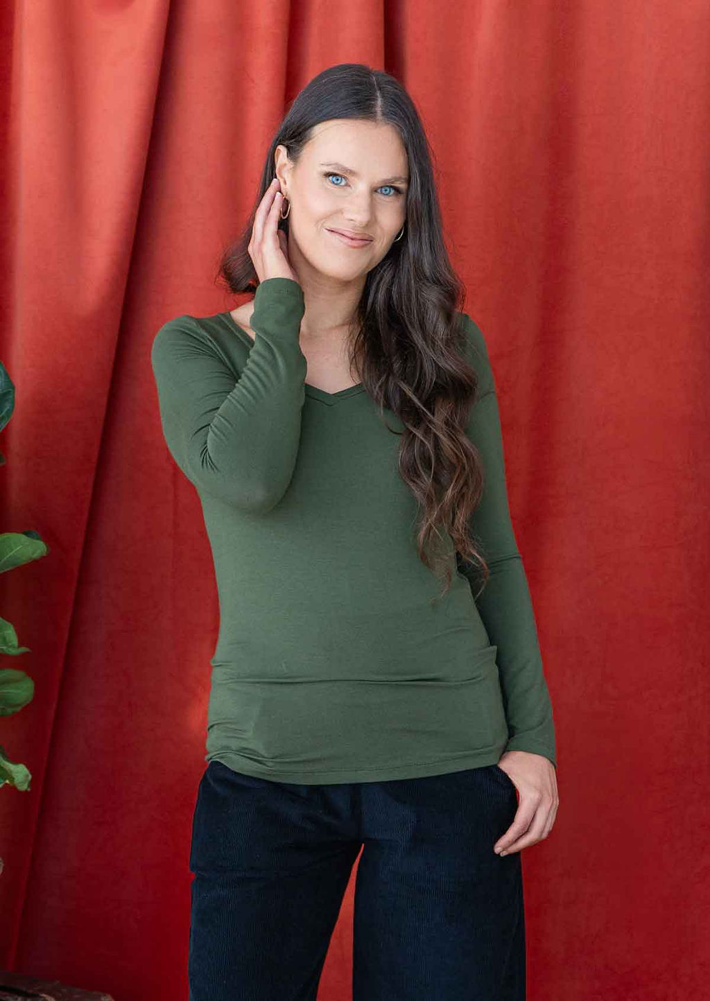 woman wearing long sleeve stretch rayon jersey top in green with v-neck 