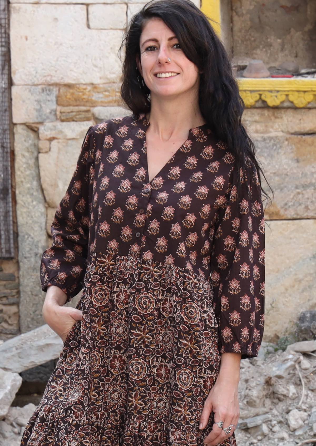 Closeup of model wearing a 3 tiered cotton dress with buttoned bodice and mandarin collar 