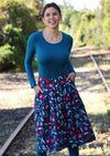 Woman wears below knee skirt with pockets.