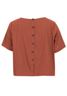 100% cotton rust shade short sleeve top with round neckline and non functional buttons down the back