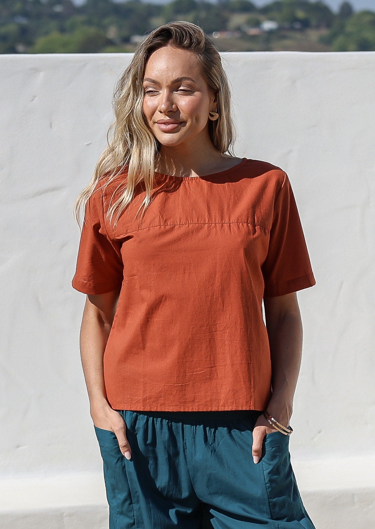 Woman wearing a plain top in rust shade, 100% cotton top with round neckline