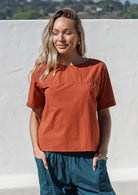 Woman wearing a plain top in rust shade, 100% cotton top with round neckline
