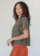 women wearing a 100% cotton olive green shade top with a rust pants standing against a white background.