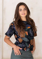 Woman wears 100% cotton loose fit top with high round neckline, short sleeves and a seam across the bust.