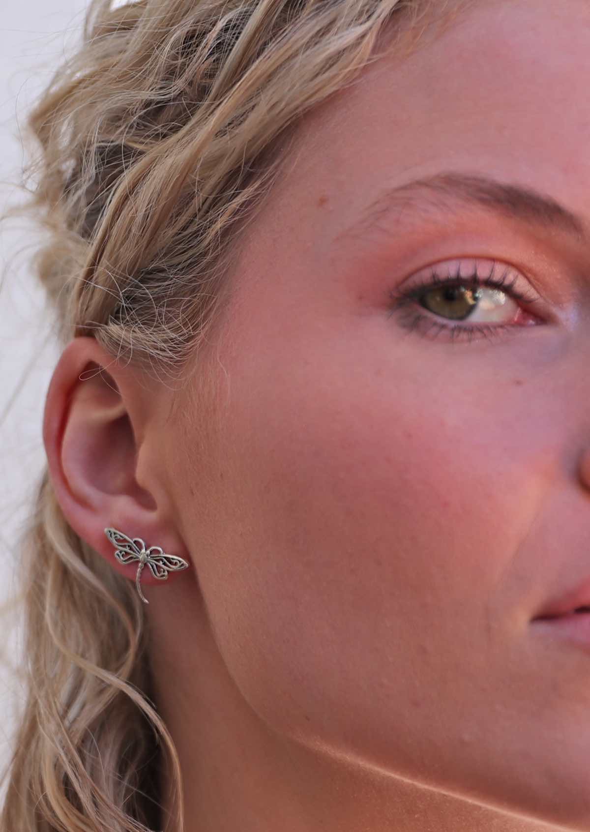 large sterling silver dragonfly stud earring in model's ear