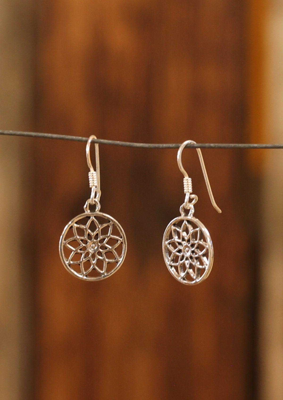 Sterling silver 13mm disc with cutout detail of sacred geometrical pattern, suspended from wire hooks
