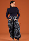 Model wearing Pilot Pant Delphi navy blue harem pant featuring pockets worn with turtle neck top