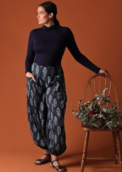 Model wearing Pilot Pant Delphi navy blue harem pant with turtle neck top