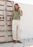 Models poses in white cotton wide leg pants with elasticated ankle