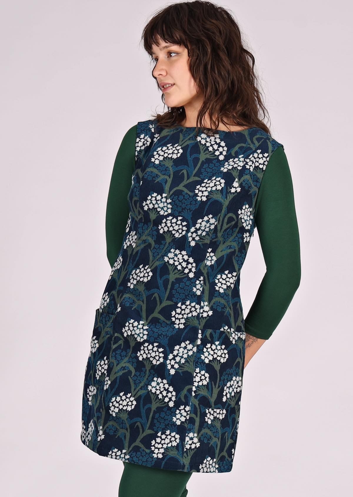 Woman wears green, blue and white floral print on dark blue base cotton corduroy sleeveless tunic
