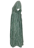 Side view of green based floral print V-neck cotton dress with pockets.