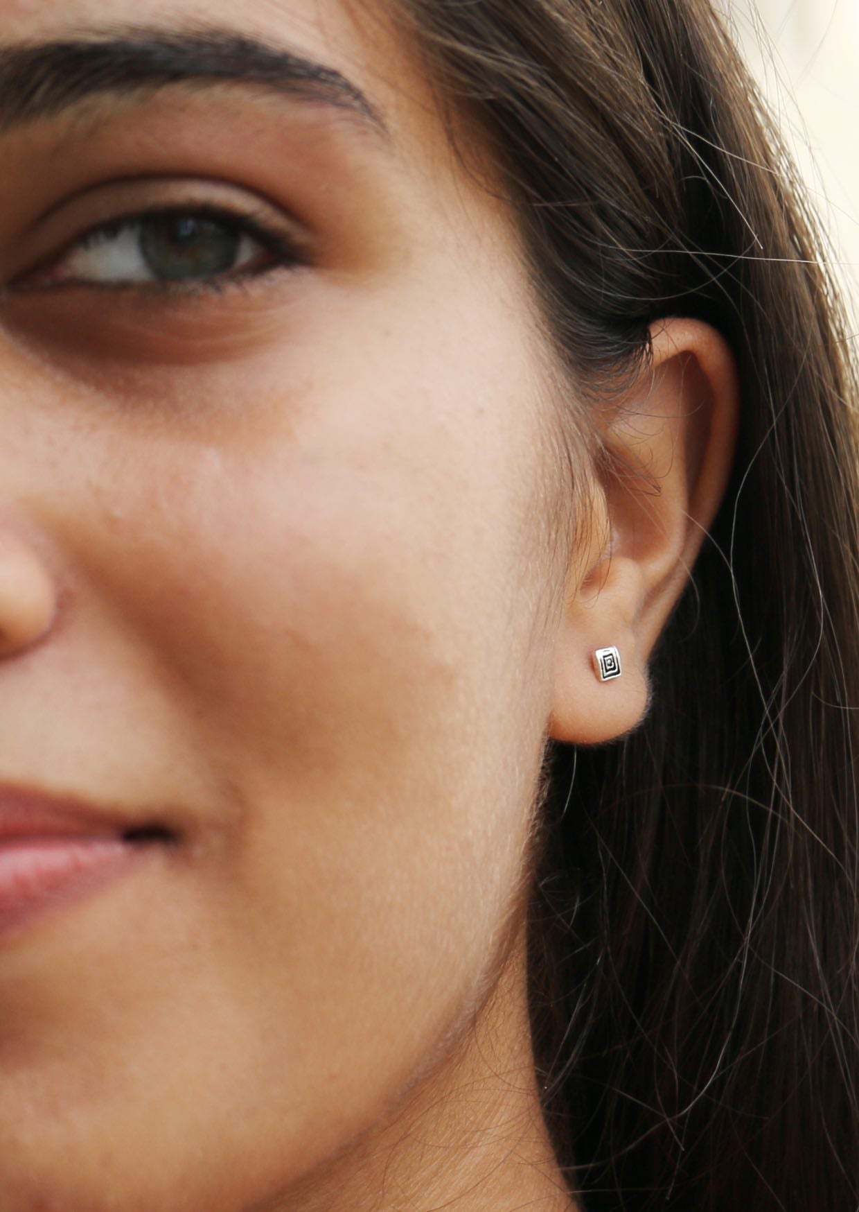 Woman wearing sterling silver Quadruple Ripple studs with secure butterfly backs