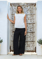 Woman wears cotton sleeveless top in plain white colour with gathers under the square neckline yoke