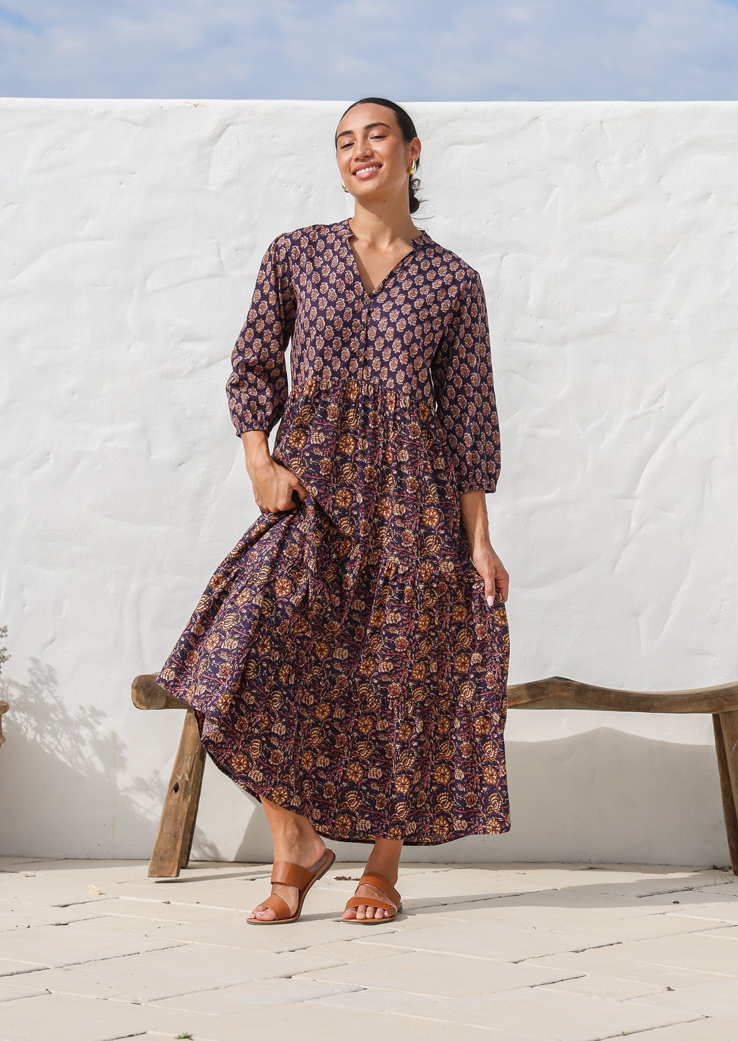 Model wearing a 3 tiered cotton maxi dress in combination of two beautiful purple based floral prints - Raani and kumari. 