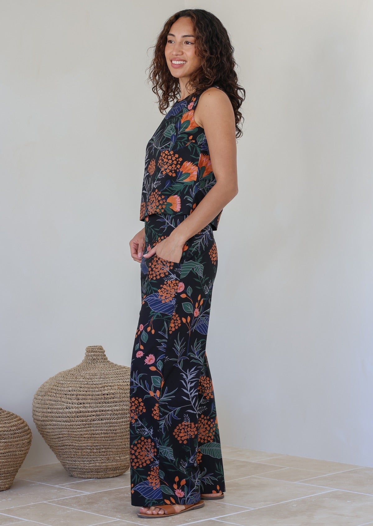 Model standing with hand in pocket wearing a matching cotton top and high waisted pant with side zipper and wide leg fit