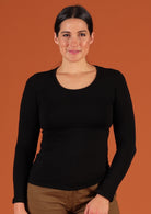 Woman wearing a round neck black long sleeve rayon top.