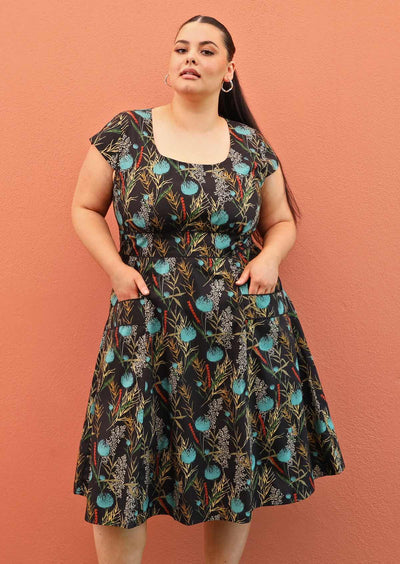 size 18 model wearing retro style cotton dress in black and teal with pockets