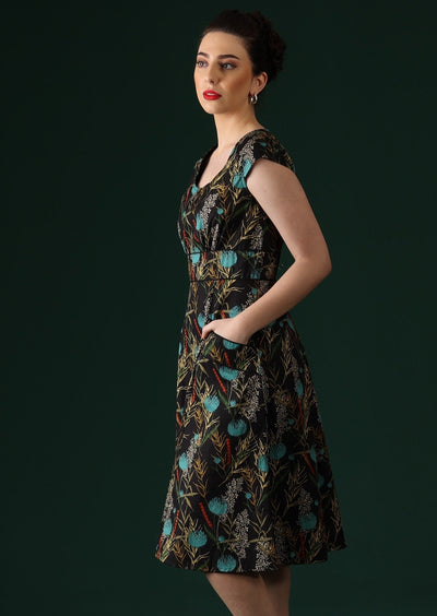 Model wears black cotton dress with cap sleeves