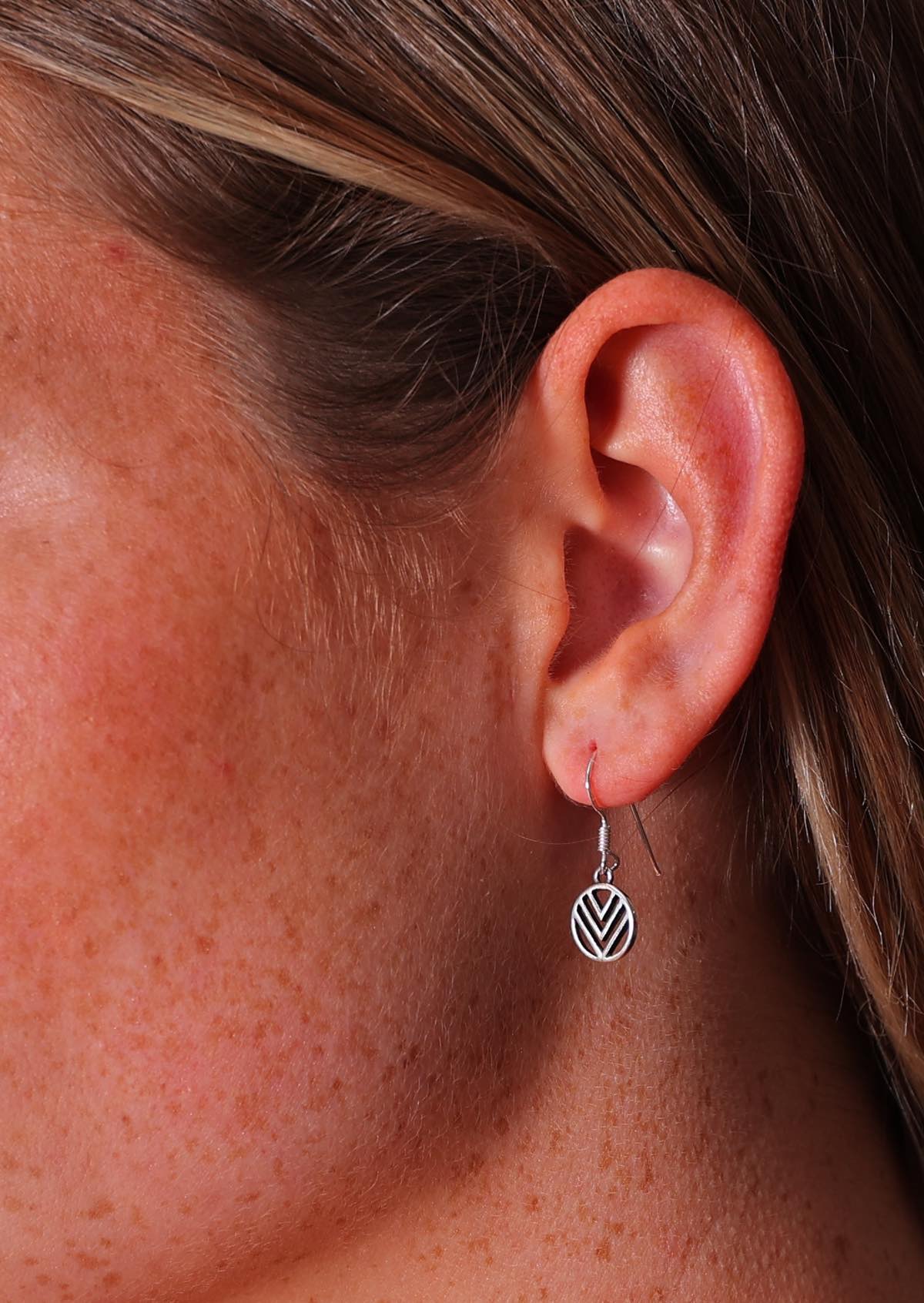 Close up of sterling silver hook earring featuring a small circle with 3 'V's inside it.