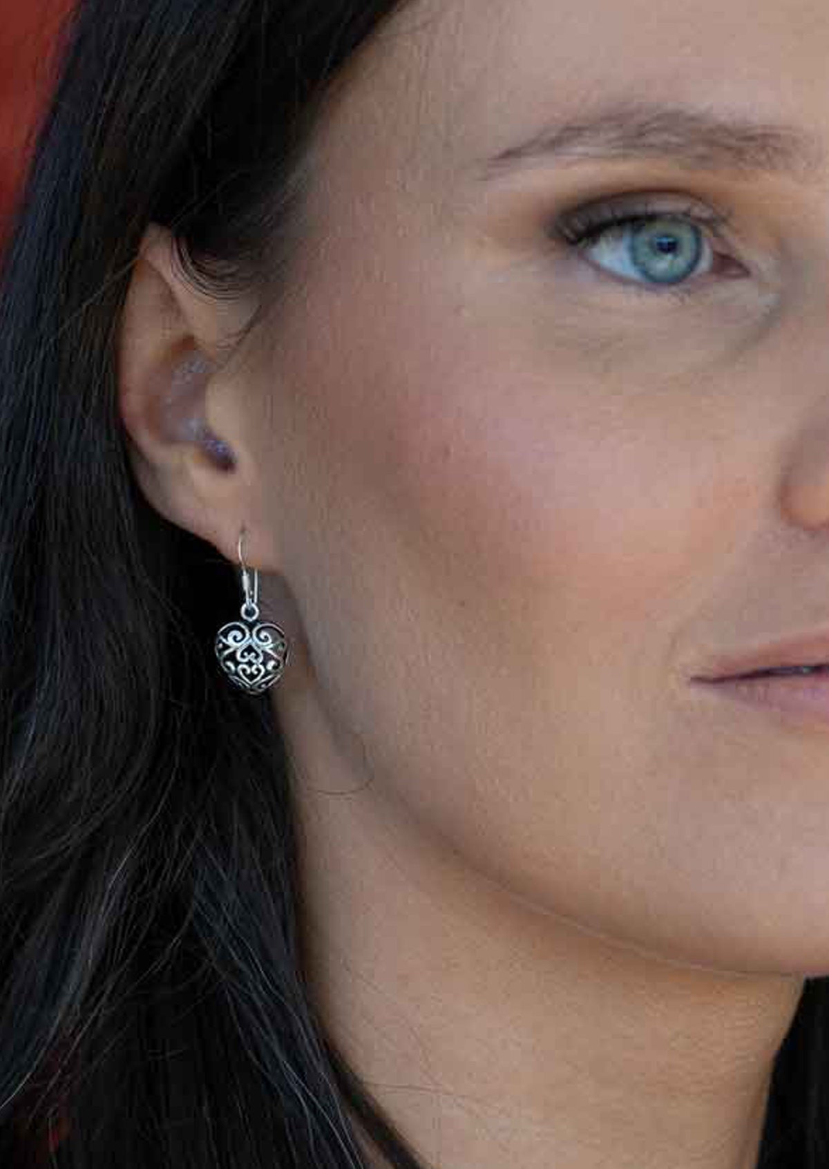 woman wearing large sterling silver filigree heart earrings