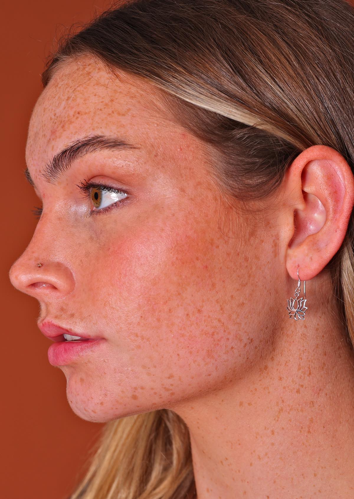 woman wearing lovely silver lotus dangly earring

