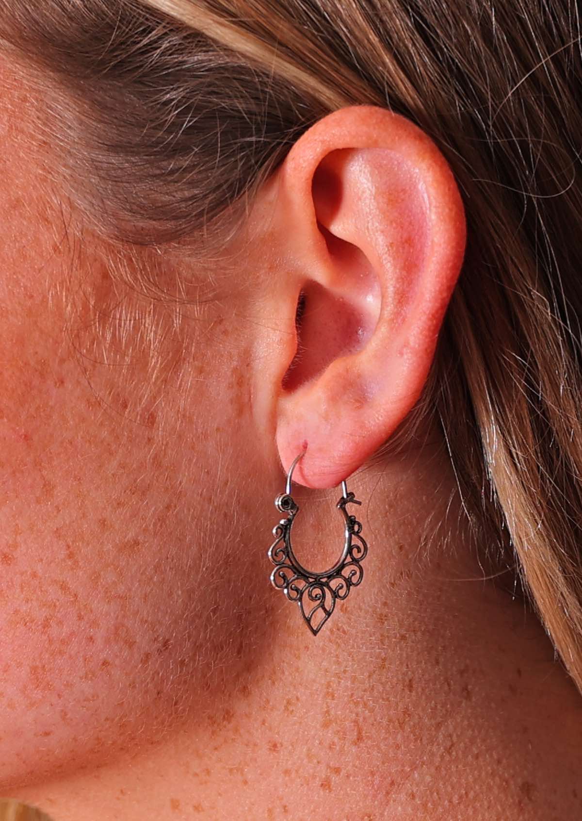 Close up of silver wire hoop with spiral details around underside