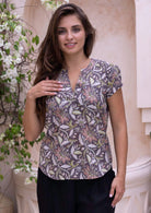 Woman wearing a light brown cotton blouse with cap sleeves