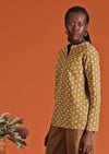 Model wearing mustard coloured long sleeve women's top
