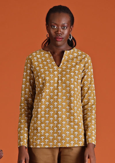 Model wearing mustard coloured long sleeve women's top with open collar