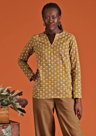 Model wearing mustard coloured long sleeve women's top with mandarin style collar