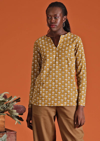 Model wearing mustard coloured long sleeve women's top with traditional Indian print