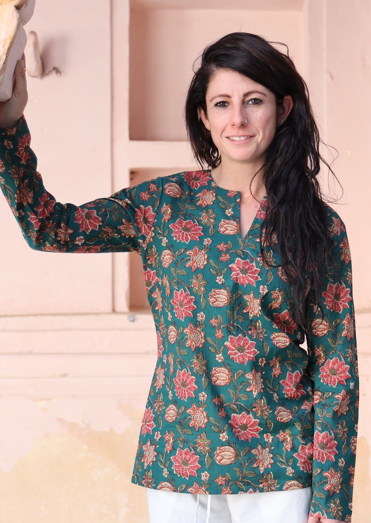 Woman wears cotton long sleeve top with keyhole cutout, in a green based floral print