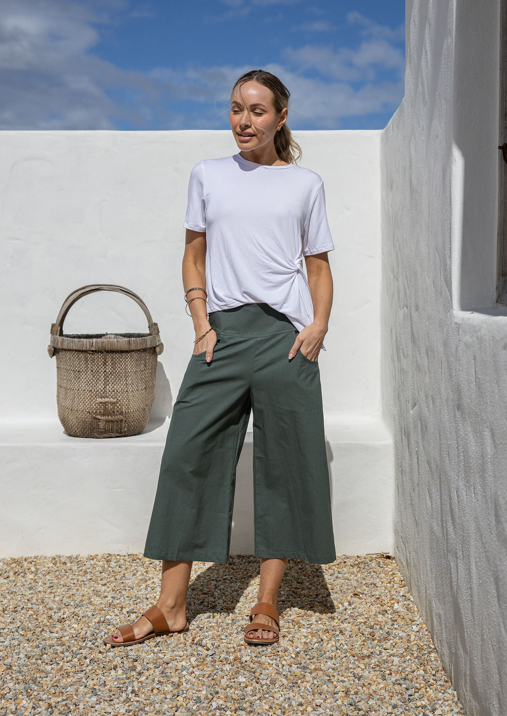 Model poses in high-waisted, Jungle Green 3/4 length wide-leg cotton pants with wide waistband and pockets, paired with a basic white rayon T-shirt