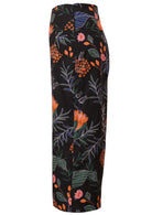 Side view of black botanic print wide leg cotton pants with 3/4 length, pockets and side zipper