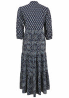 Back view of a full length maxi dress with 3 tiered flowy skirt, mandarin collar, buttoned bodice and pockets