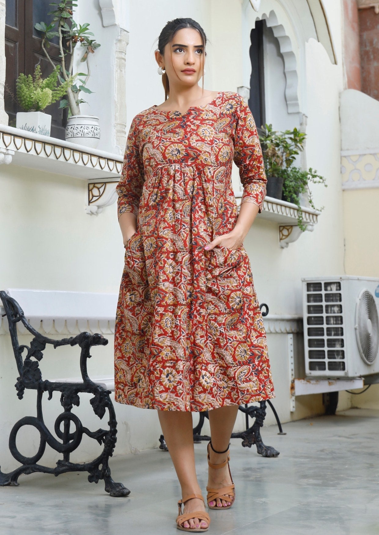 Model wears lightweight cotton floral print dress in earthy tones
