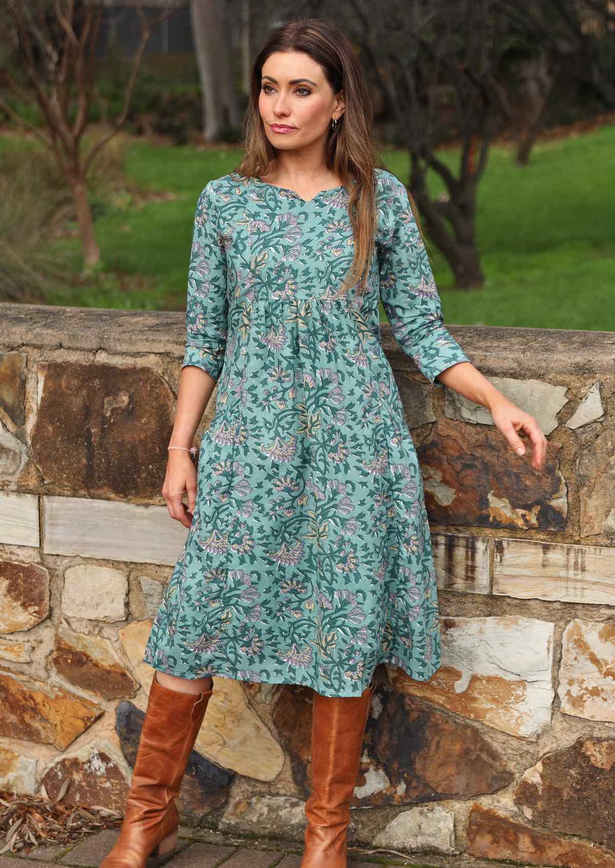 Model in indian floral printed dress featuring 3/4 sleeves, pockets and keyhole cutout neckline.