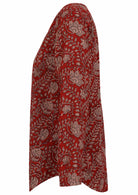 Side image of long sleeve cotton top with red based floral print.