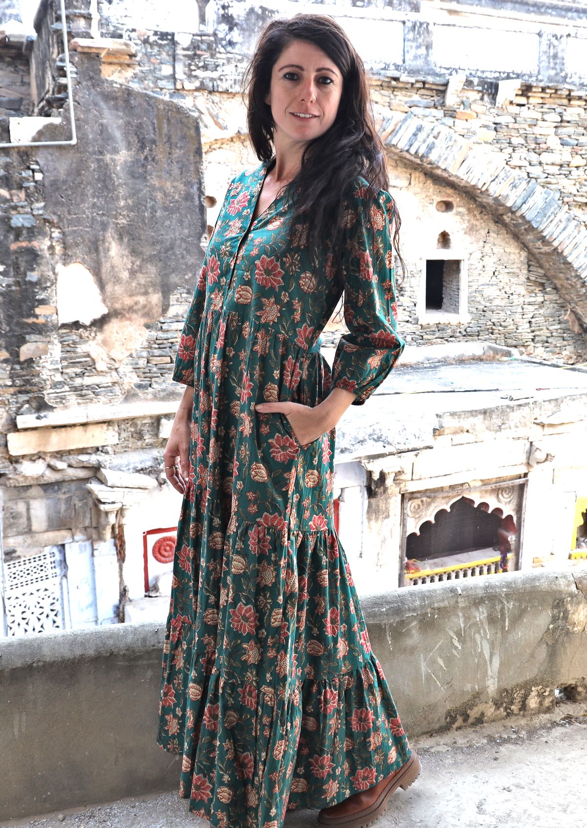 Model wearing a 100% cotton 3 tiered maxi dress with 3/4 sleeves, buttoned bodice and one hand in pocket.