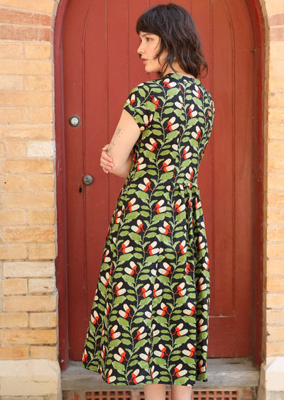 Model wears retro style cotton dress with pin tucks at back